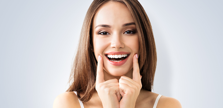 woman lifting the corners of her mouth with her fingers