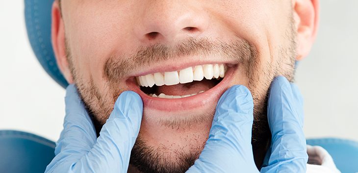 Gloved hands framing a man's smile