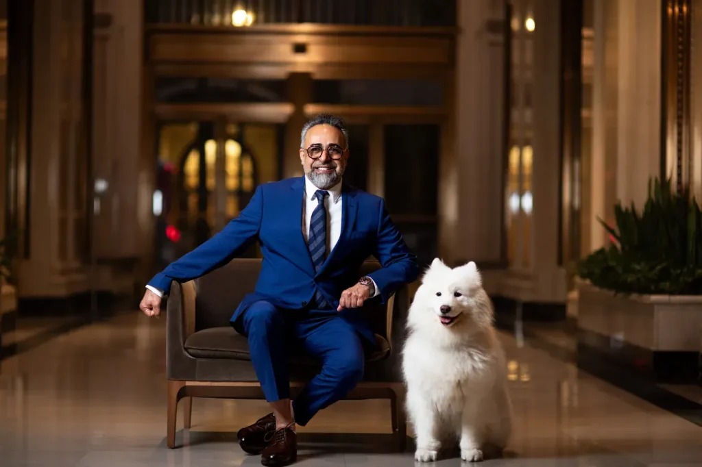 Dr. Kourosh Yousefzadeh seated in the lobby beside the practice dog