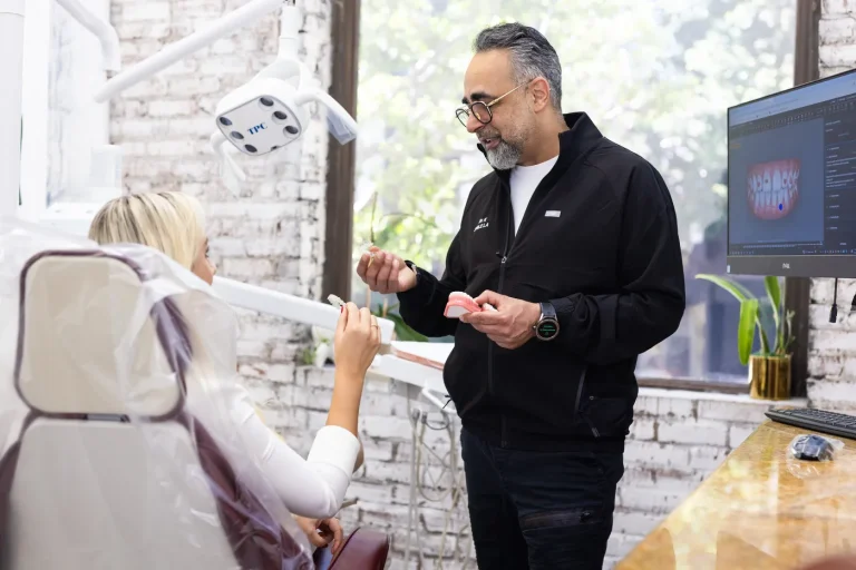 Dr. Kourosh Yousefzadeh talking a patient through a treatment plan beside the operatory window