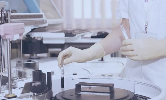 Gloved hands operating equipment in a dental laboratory