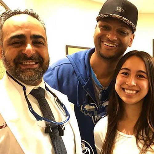 Two patients standing with a Smile LA doctor after treatment