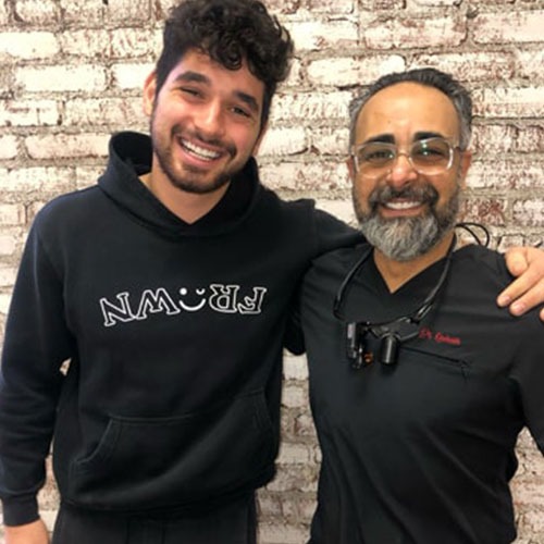 A patient standing with Dr. Kourosh Yousefzadeh after treatment