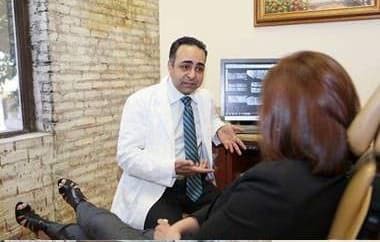 Dentist reviewing images on a monitor with a seated patient