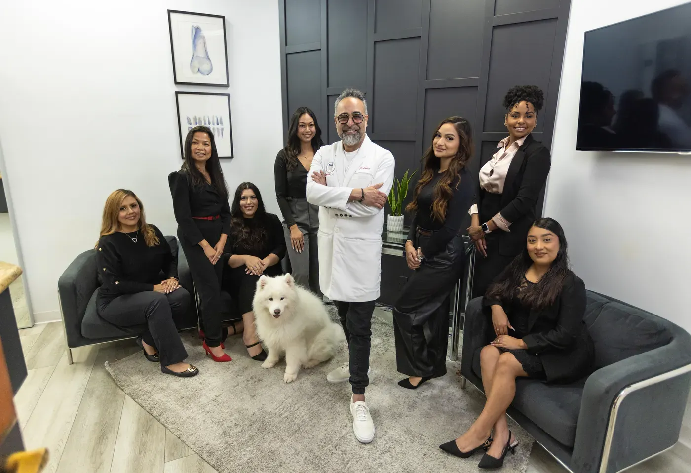 The full Smile LA team standing together in the office lounge with the practice dog