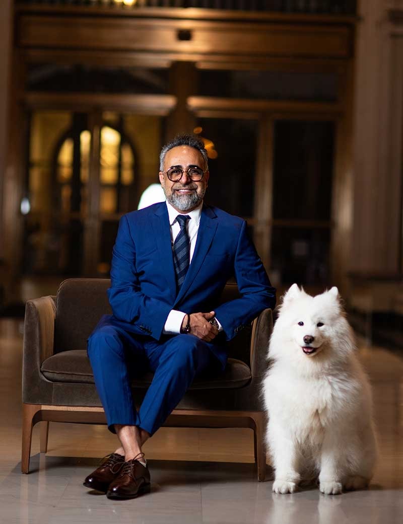 Dr. Kourosh Yousefzadeh seated in the office lobby beside a white Samoyed