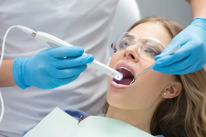 A dentist using an intraoral camera on a patient