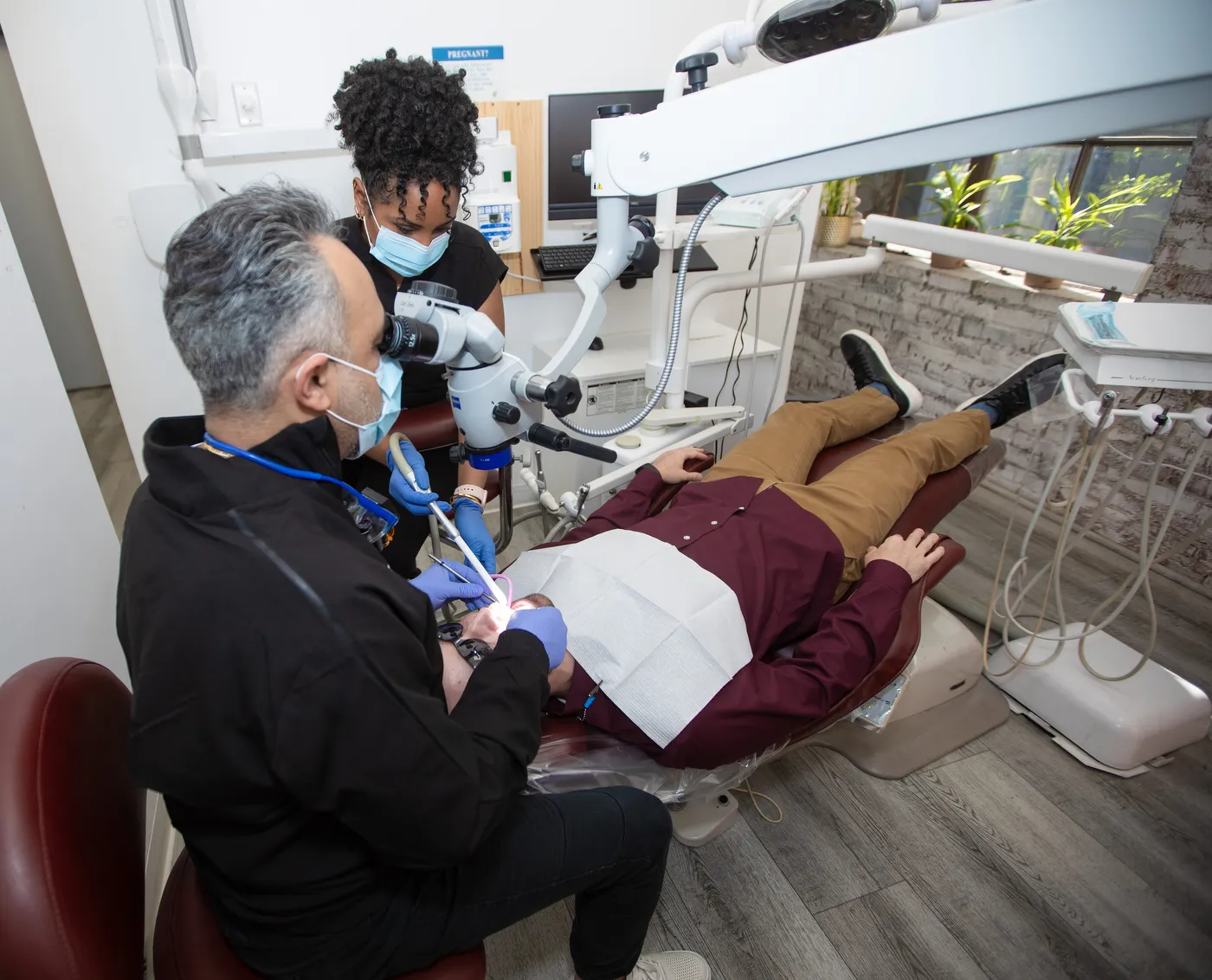 Dr. Kourosh Yousefzadeh working under the surgical microscope with an assistant