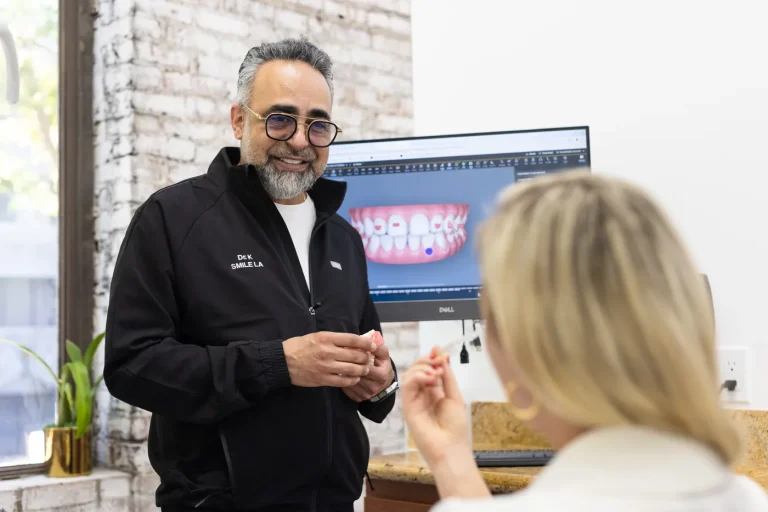 Dr. Kourosh Yousefzadeh showing a patient a digital smile design on the wall screen