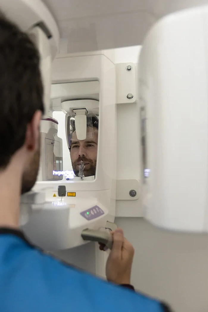 A patient positioned in a panoramic X-ray machine