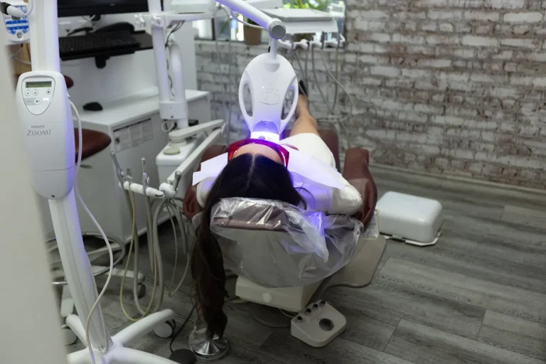 A patient under the Zoom whitening lamp in the treatment chair