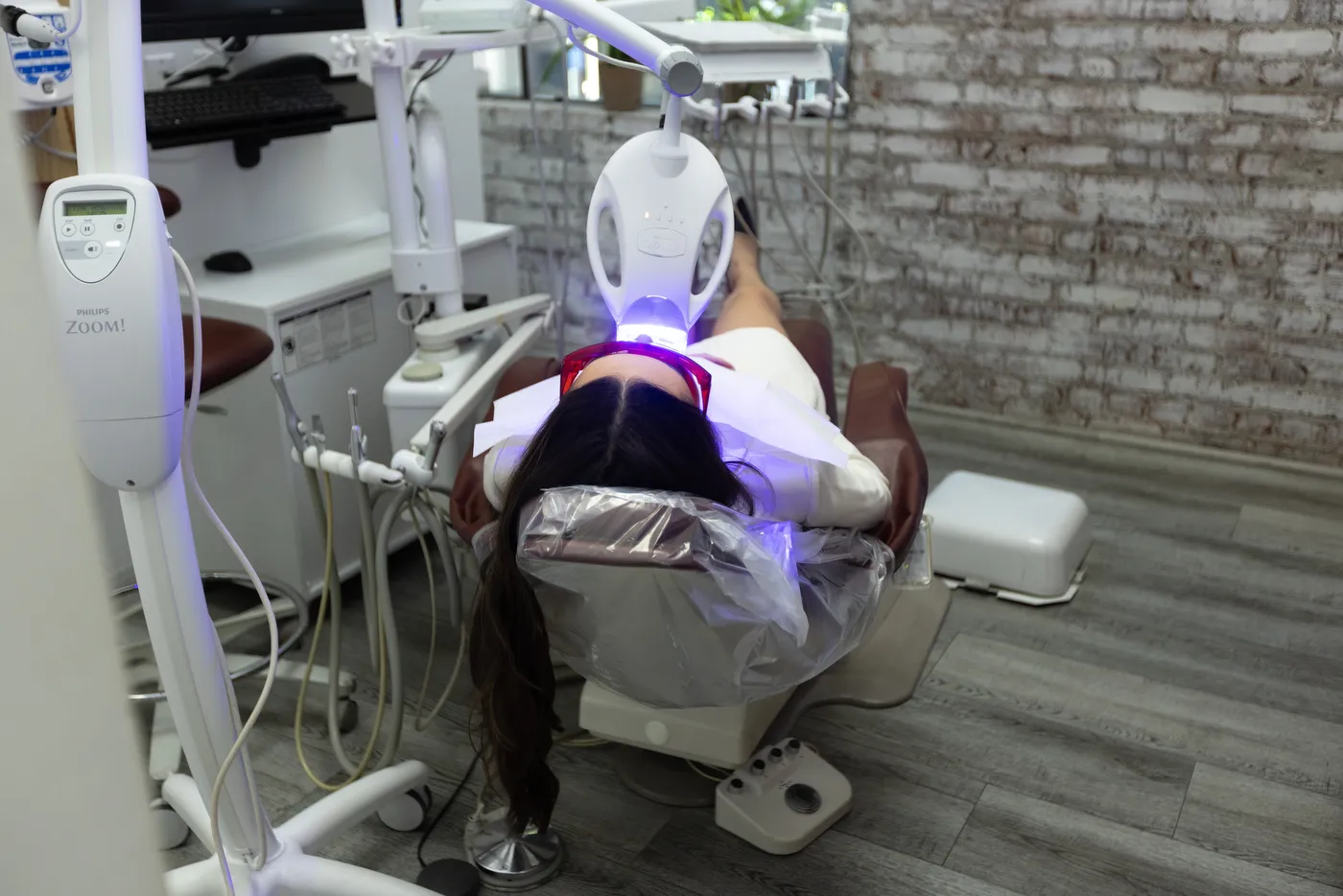 A patient under the Zoom whitening lamp in the treatment chair