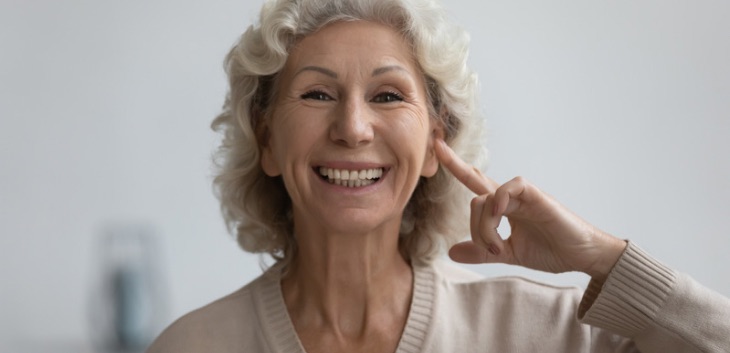 Woman pointing at her smile