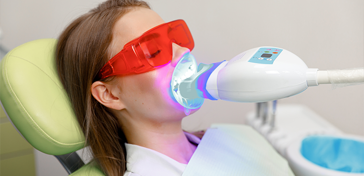 Teeth whitening light being shone on a woman's teeth
