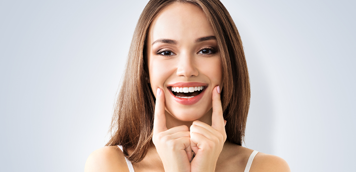 Woman lifting the corners of her mouth with her fingers